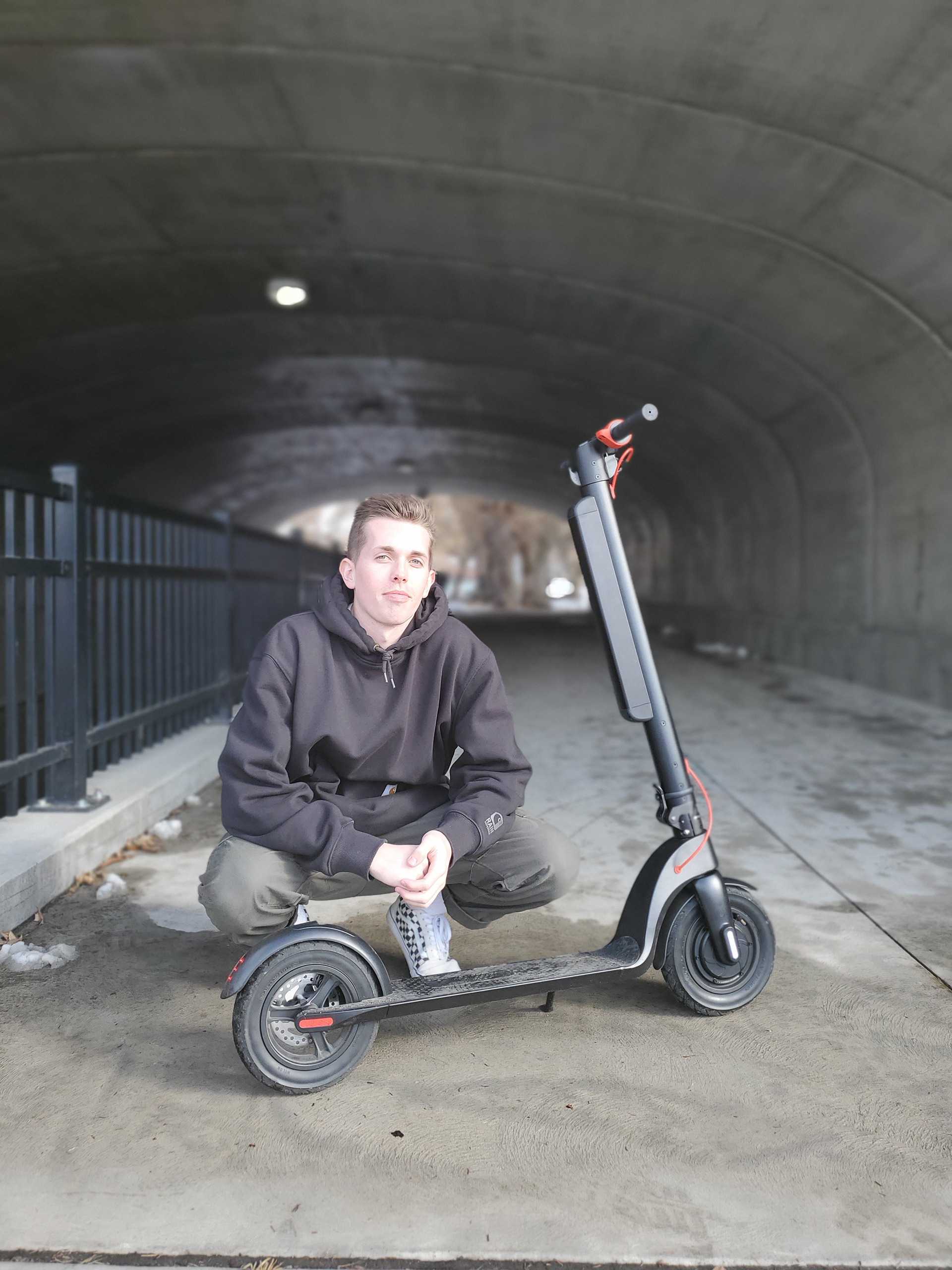 man next to an electric scooter